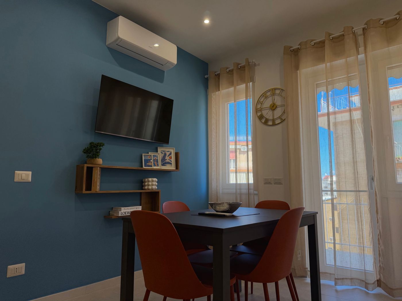 Tavolo da pranzo con quattro sedie terracotta davanti alla finestra